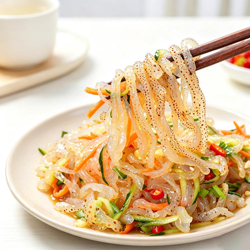 Jellyfish strips tossed with vegetables and sesame on a plate