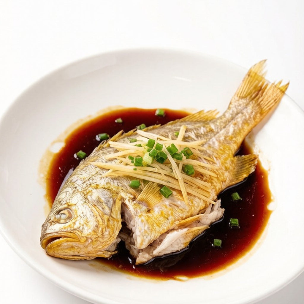 Two pan-fried yellow croakers with lemon and rosemary on a wooden board